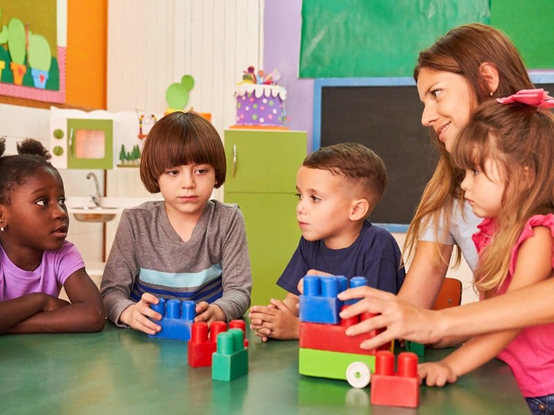 Four student and one teacher play with toy